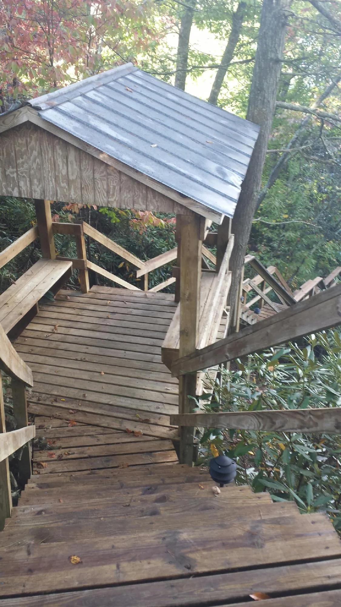 Metal roofed shelter over wooden steps on a wooded walkway — Skylight Repair & Installation work by our crew in Lehman