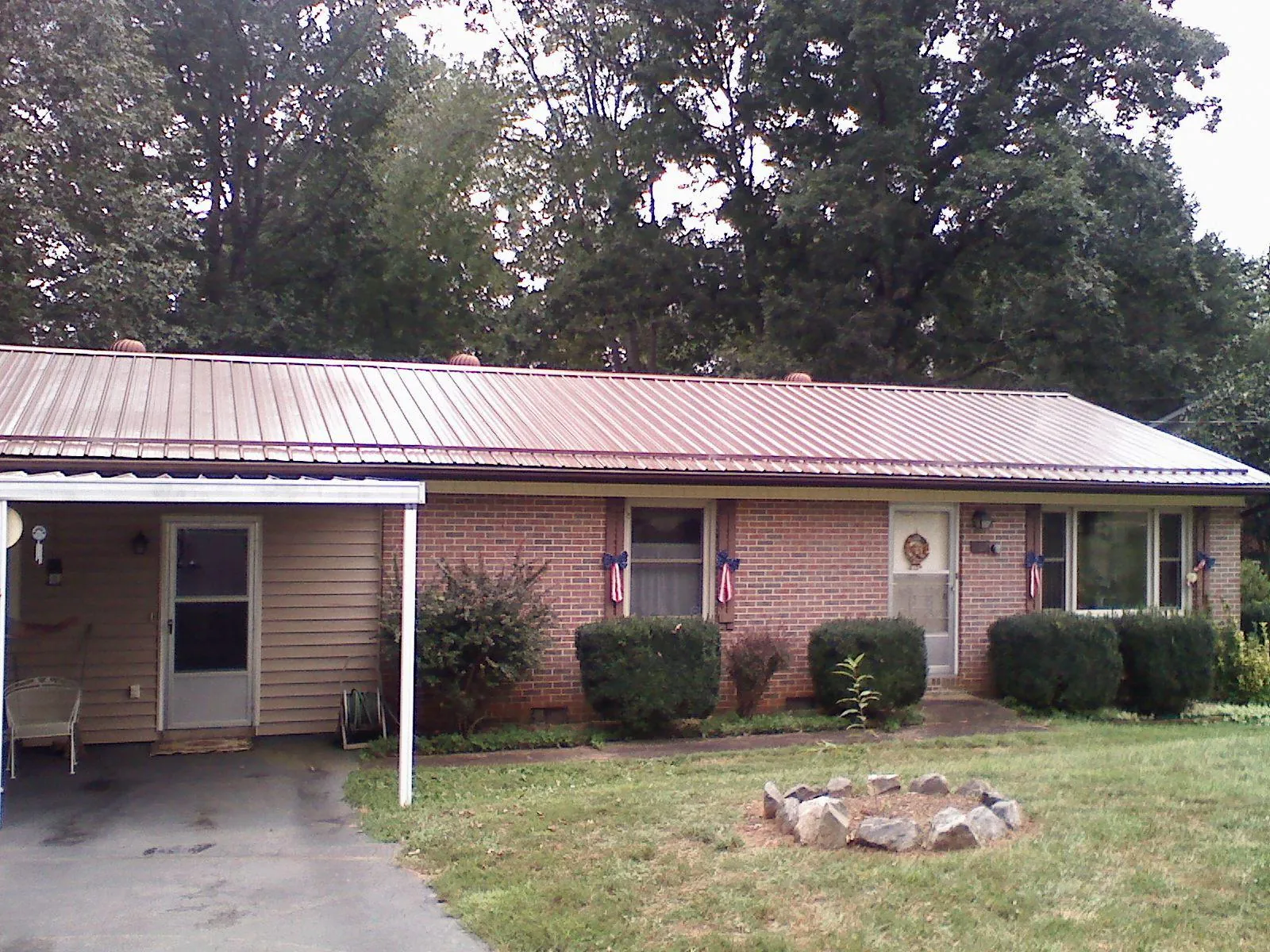 Bronze metal roof and carport on a brick ranch home — Roof Repair work by our crew in Lehman